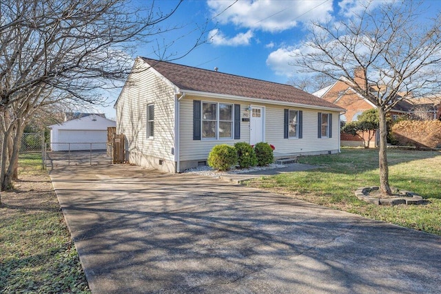 bungalow with a garage, an outdoor structure, and a front lawn