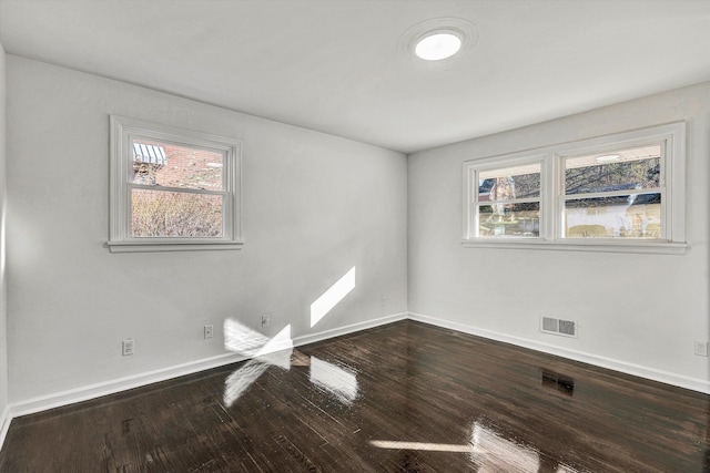 empty room with hardwood / wood-style floors and a healthy amount of sunlight