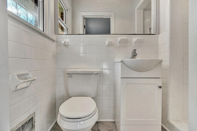 bathroom featuring vanity, toilet, and tile walls