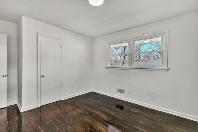 unfurnished bedroom featuring baseboards, visible vents, and wood finished floors