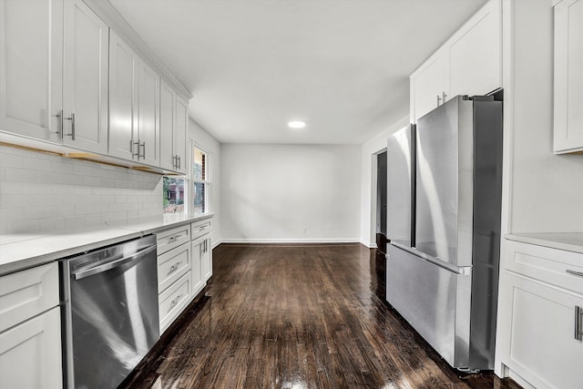 kitchen featuring tasteful backsplash, white cabinets, dark wood-style floors, stainless steel appliances, and light countertops