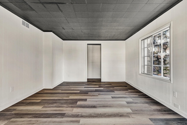 empty room with dark wood-type flooring and visible vents