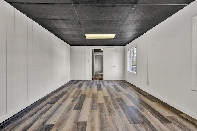 empty room featuring wood walls and dark hardwood / wood-style flooring