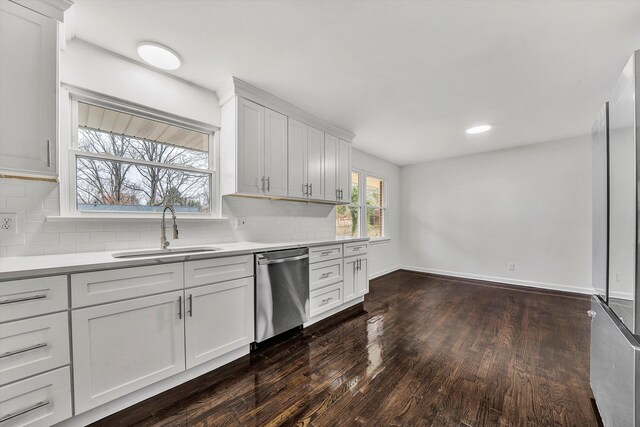 room details featuring backsplash, light stone counters, white cabinetry, and sink