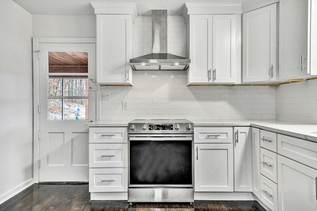 kitchen featuring dark wood-style flooring, white cabinets, wall chimney range hood, backsplash, and stainless steel electric stove