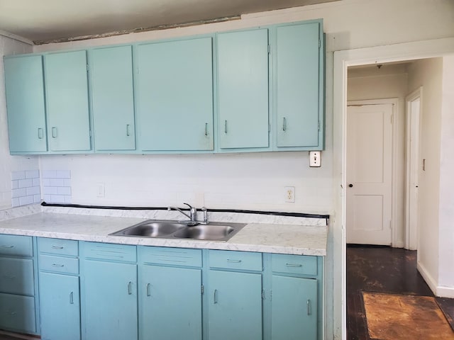 kitchen featuring blue cabinets, light countertops, and a sink