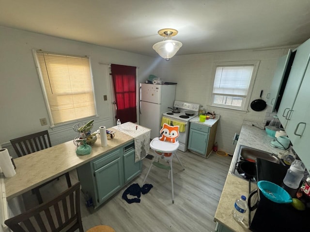 kitchen with light hardwood / wood-style floors, white appliances, and sink