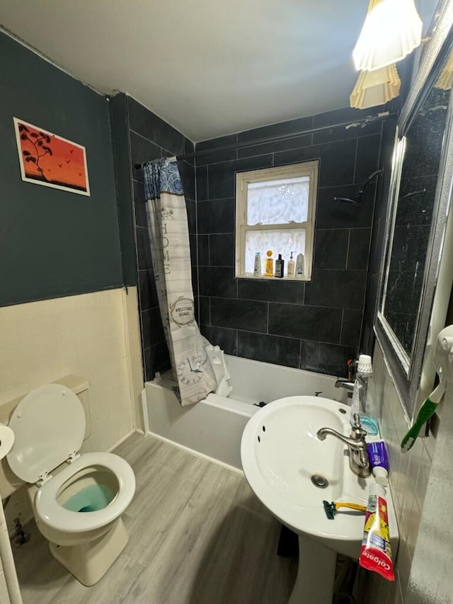 full bathroom featuring sink, toilet, shower / bathtub combination with curtain, and hardwood / wood-style flooring