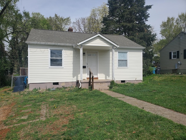 bungalow-style house featuring a front yard, a chimney, crawl space, and roof with shingles