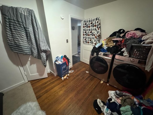 laundry area with washer and clothes dryer, dark hardwood / wood-style floors, and cabinets