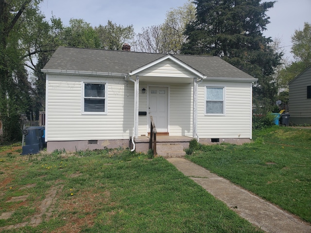bungalow-style home featuring a shingled roof, crawl space, and a front lawn