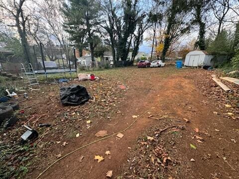 view of yard with a trampoline and a shed