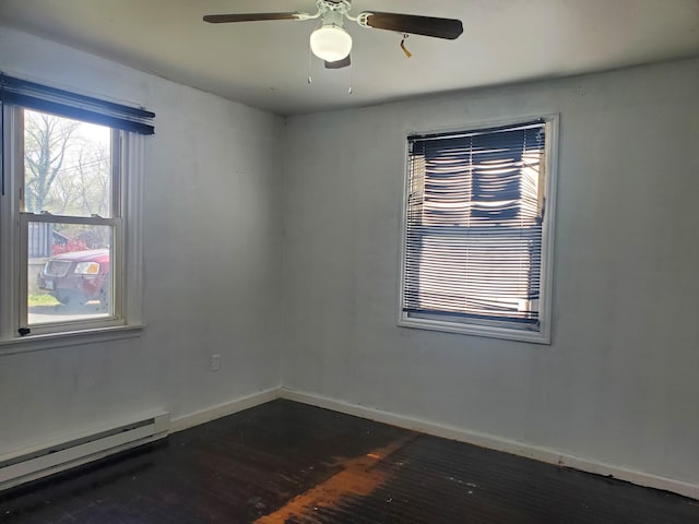 empty room with a baseboard heating unit, baseboards, a ceiling fan, and dark wood-style flooring