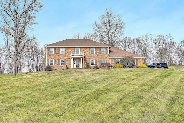 view of front of home with a balcony and a front yard