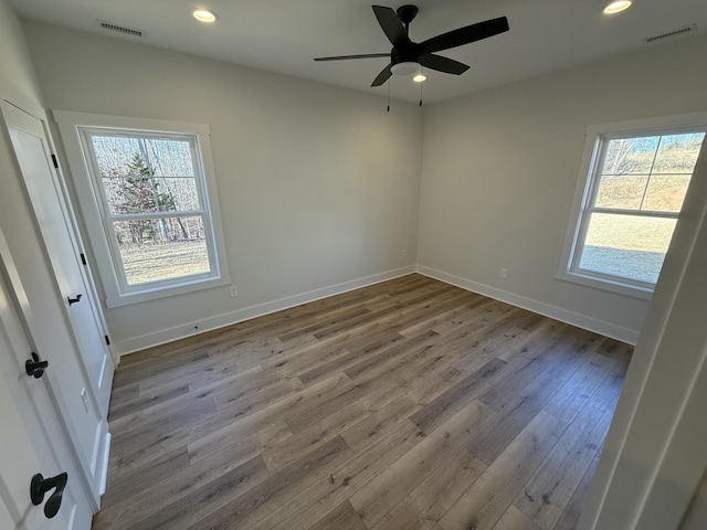 spare room with hardwood / wood-style flooring, a wealth of natural light, and ceiling fan