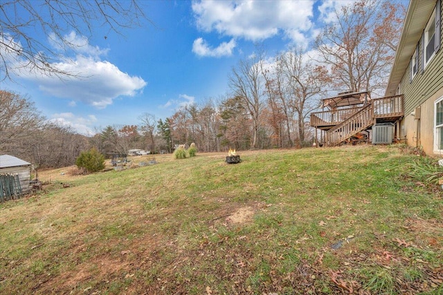 view of yard with a deck, an outdoor fire pit, and central AC