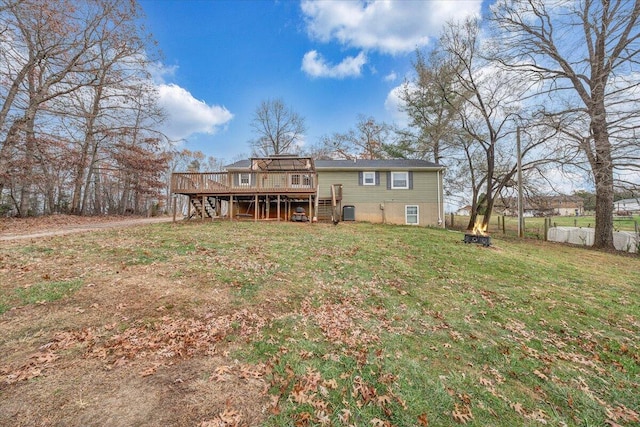 back of house featuring a lawn and a deck