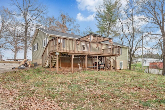 back of house featuring a lawn and a wooden deck