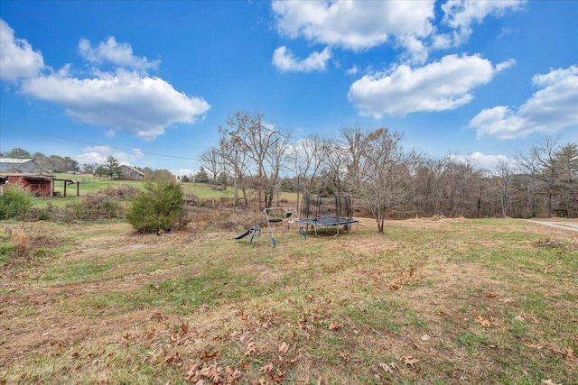 view of yard with a rural view and a trampoline