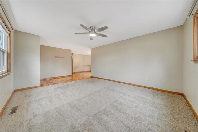 empty room with ceiling fan and light colored carpet