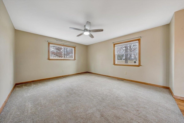 spare room with ceiling fan and light carpet