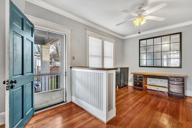 entryway with built in desk, ceiling fan, crown molding, and hardwood / wood-style flooring