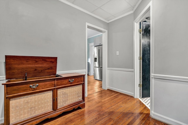 corridor with crown molding and light wood-type flooring