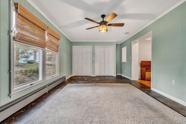 interior space with ceiling fan, wood walls, ornamental molding, and a baseboard radiator