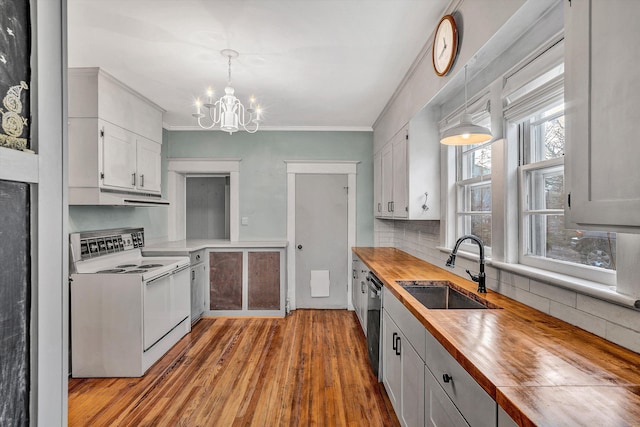 kitchen with butcher block countertops, electric range, a notable chandelier, decorative light fixtures, and sink