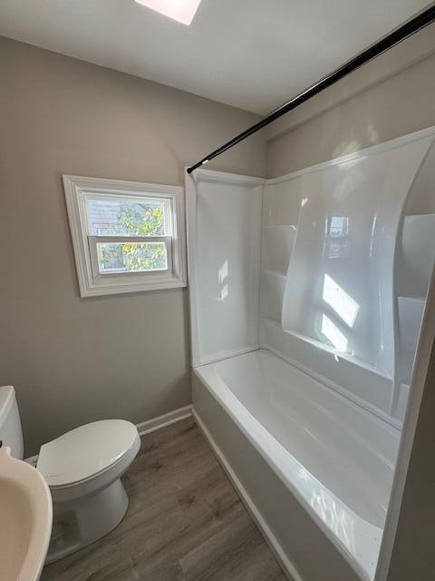 full bathroom with bathtub / shower combination, hardwood / wood-style floors, toilet, and sink