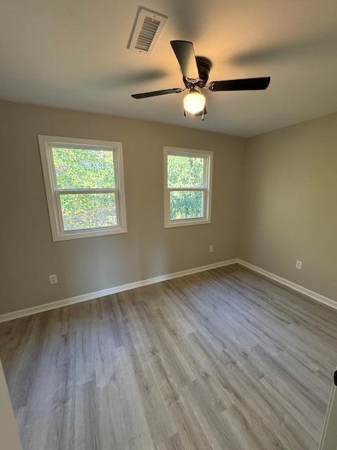 unfurnished room with ceiling fan, plenty of natural light, and light hardwood / wood-style flooring