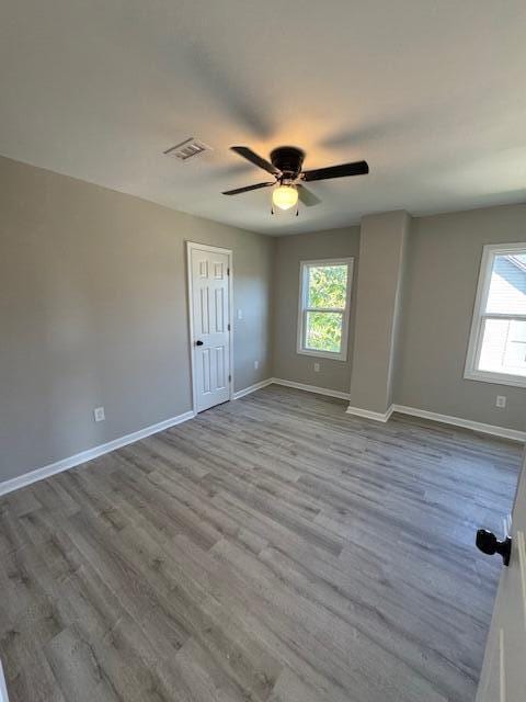 unfurnished room with ceiling fan, a healthy amount of sunlight, and light wood-type flooring