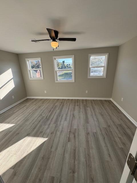 unfurnished room with ceiling fan and dark hardwood / wood-style floors