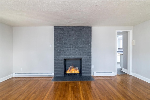 unfurnished living room featuring wood-type flooring, a textured ceiling, and baseboard heating