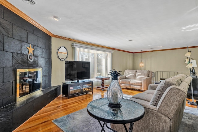 living room with ornamental molding, a fireplace, and hardwood / wood-style floors