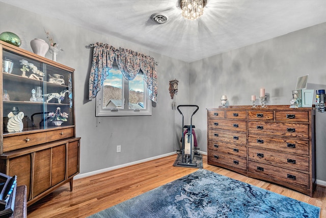 miscellaneous room with light hardwood / wood-style floors and a chandelier