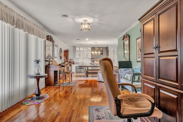 interior space with ornamental molding, a chandelier, and light wood-type flooring