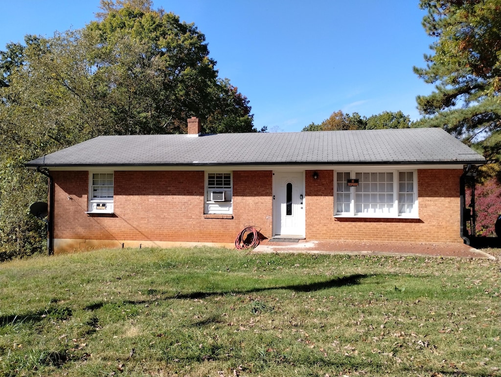 ranch-style house featuring cooling unit and a front yard