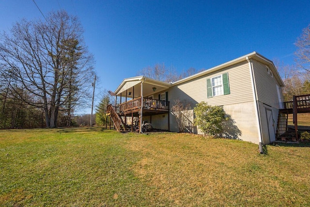 back of house featuring a garage, a yard, and a wooden deck