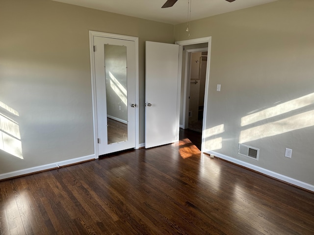 unfurnished room with ceiling fan and dark wood-type flooring