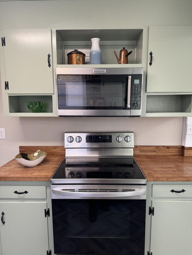 kitchen featuring white cabinetry, stainless steel appliances, and wood counters