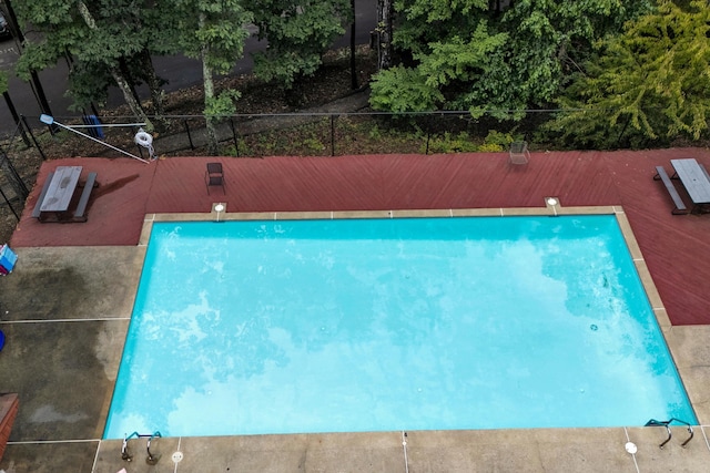 view of swimming pool featuring a diving board