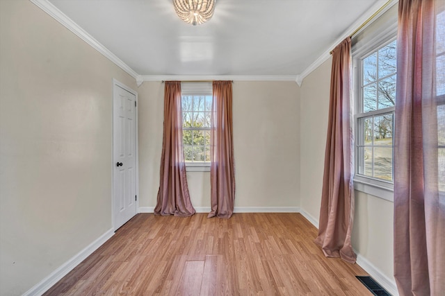 unfurnished room with ornamental molding and light wood-type flooring