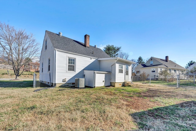 rear view of house with a yard and central AC