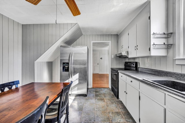 kitchen featuring stainless steel fridge with ice dispenser, electric range, white cabinetry, and wood walls