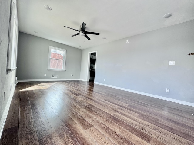 spare room featuring dark wood-style floors, baseboards, and a ceiling fan