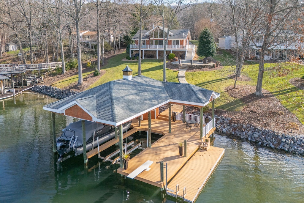 dock area featuring a deck with water view and a yard