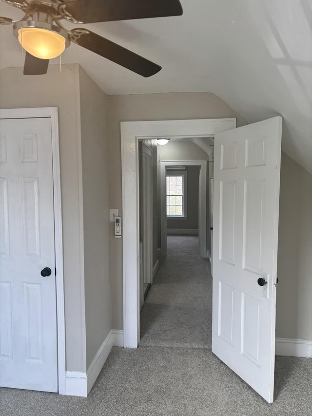 corridor with carpet and vaulted ceiling