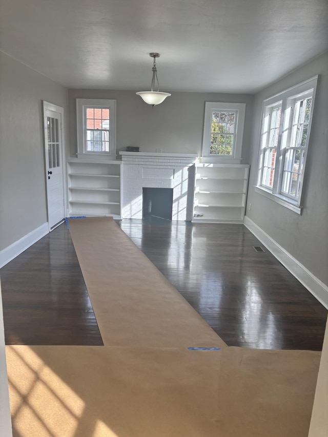 interior space with dark hardwood / wood-style floors and a brick fireplace