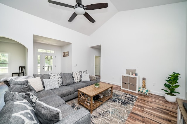 living room featuring wood-type flooring, high vaulted ceiling, and ceiling fan